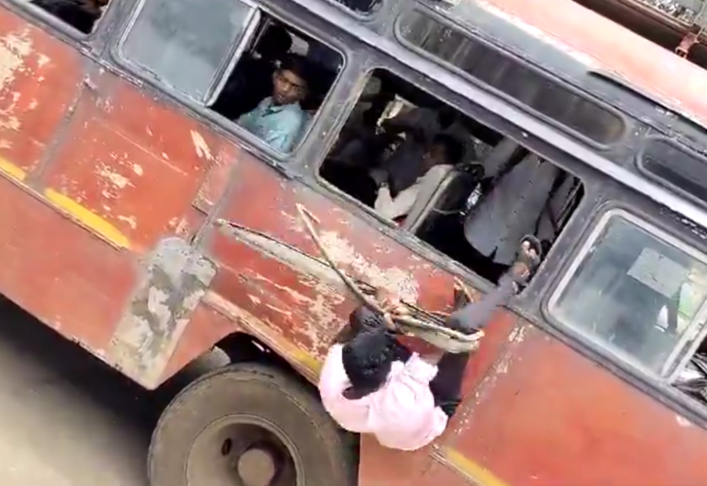 Man falls through old bus window at bus stand in western India, draws crowd