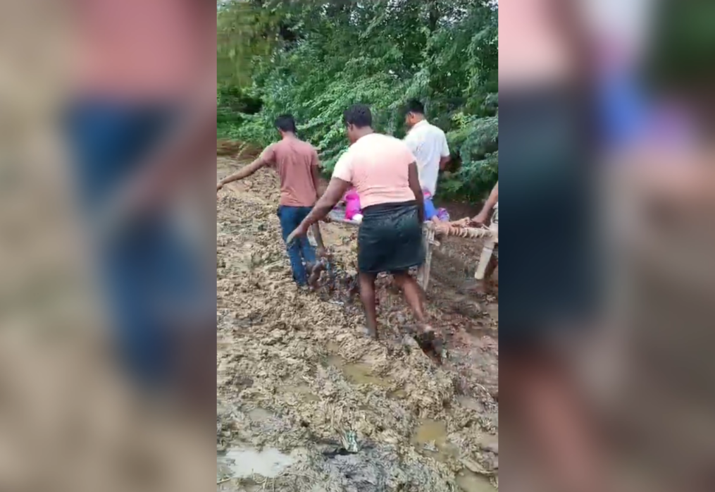 People carried sick woman through muddy ways to ambulances in northern India